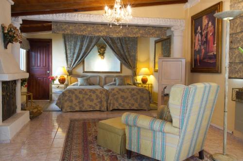 a bedroom with two beds and a couch and a chair at La Mirage Garden Hotel & Spa in Cotacachi