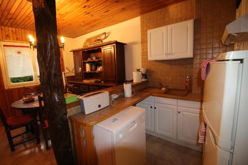 a kitchen with white cabinets and a white refrigerator at Toupinat in Montferrier