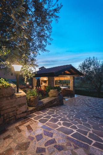 a house with a stone walkway in front of a building at Guest House Nena in Motovun
