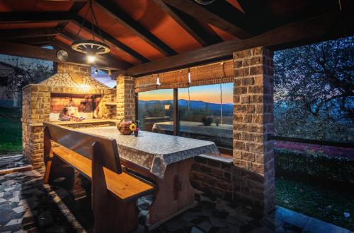 a stone patio with a bench and a fireplace at Guest House Nena in Motovun