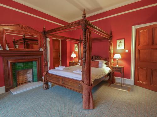 a bedroom with a four poster bed and a fireplace at Braeriach - Mar Lodge Estate in Ballater