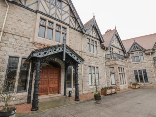 a large brick building with a wooden door at Dalvorar - Mar Lodge Estate in Ballater