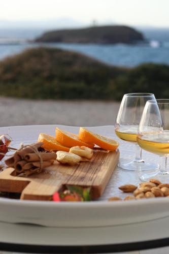 a table with two glasses of wine and orange slices at Hotel Grotta in Naxos Chora