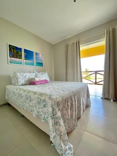 a bedroom with a bed and a large window at Condomínio Villa das Aguas com wi-fi in Praia do Saco
