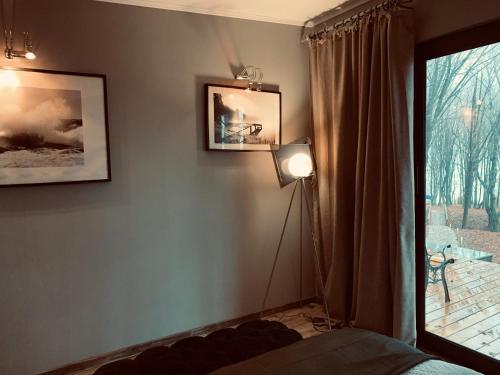 a bedroom with a lamp next to a window at Luxury Lake House & Glamping in Teşila