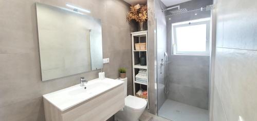 a bathroom with a sink and a shower and a toilet at HD Mogán Coral Apartments in Puerto de Mogán