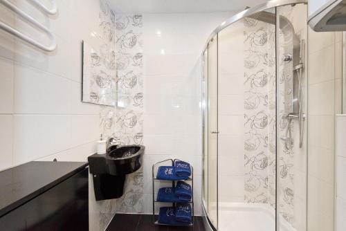 a bathroom with a sink and a shower at Gdańskie Apartamenty - Apartamenty - Długa z Widokiem Na Ratusz i nad Motławą in Gdańsk