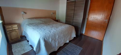 - une petite chambre avec un lit et un placard en bois dans l'établissement LU-MAR, à Caviahue
