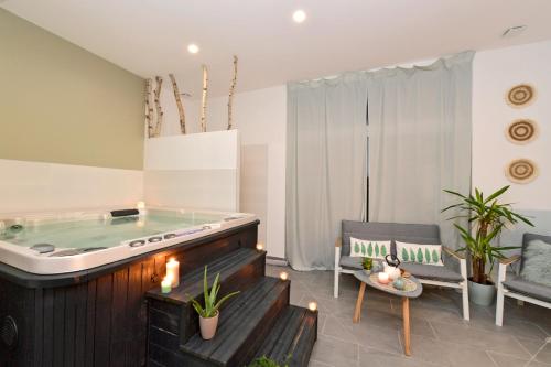 聖康坦的住宿－Chambres d'hotes Les Nuits Pastel，客厅设有按摩浴缸和两把椅子