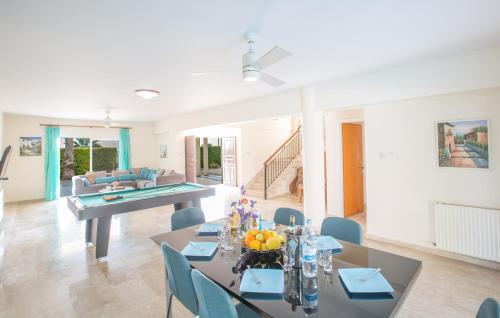 a dining room with tables and chairs and a pool table at Papaya Royal Villa in Ayia Napa