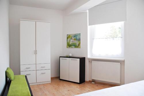 a bedroom with a white cabinet and a window at Appartementanlage-Ferienwohnungen Weiße Möwe in Sassnitz