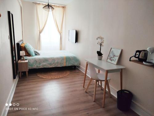 a bedroom with a bed and a table and a window at 157m2, 4 chambres, 4 salles de bains, 2 WC, 2 parkings en hypercentre in Valence