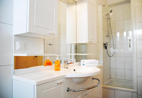 a white bathroom with a sink and a shower at Appartementanlage-Ferienwohnungen Weiße Möwe in Sassnitz