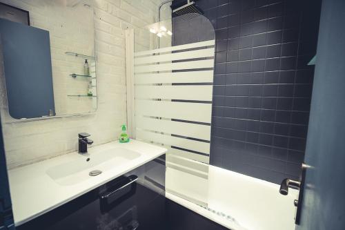 La salle de bains blanche est pourvue d'un lavabo et d'un miroir. dans l'établissement Appart ROMANTIQUE dans HYPER CENTRE wifi, à Troyes