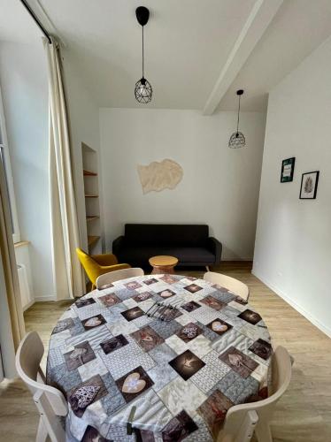 a living room with a table with a quilt on it at Résidence Bonnecaze in Eaux-Bonnes