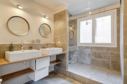 uma casa de banho com 2 lavatórios e um chuveiro em Le Gambetta - T3 Standing avec Parking, Wifi, Netflix em Laval