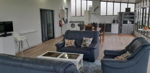 ein Wohnzimmer mit 2 blauen Sofas und einer Küche in der Unterkunft Lourenço House in Póvoa de Varzim