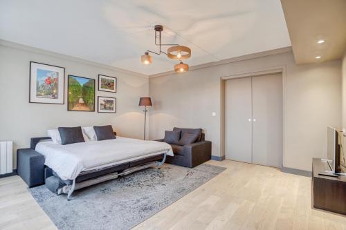 a bedroom with a bed and a chair at Le Gambetta - T3 Standing avec Parking, Wifi, Netflix in Laval