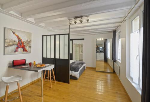ein Wohnzimmer mit einem Bett und einem Tisch in einem Zimmer in der Unterkunft Hyper Centre Place Imbach in Angers