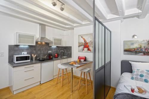 - une cuisine avec une table et un lit dans une chambre dans l'établissement Hyper Centre Place Imbach, à Angers