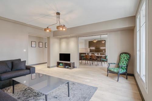 a living room with a couch and a table at Le Gambetta - T3 Standing avec Parking, Wifi, Netflix in Laval