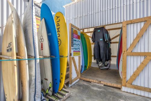 a bunch of surfboards are lined up against a wall at Selina Boavista Ericeira in Ericeira