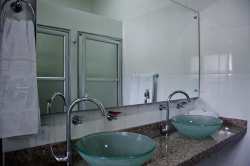 a bathroom with two green sinks and two faucets at Hotel Chucarima in Cúcuta