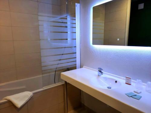 バゼイユにあるLogis Auberge du portの洗面台、シャワー、鏡を備えたバスルーム