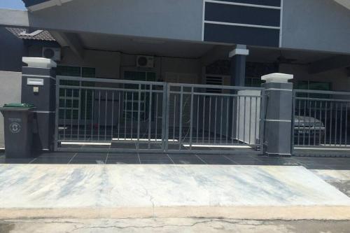 metalowa brama przed budynkiem w obiekcie Homestay Ayi w mieście Ayer Keroh