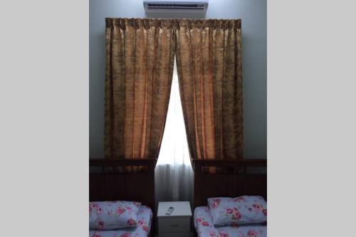 Pokój z 2 krzesłami i oknem w obiekcie Homestay Ayi w mieście Ayer Keroh