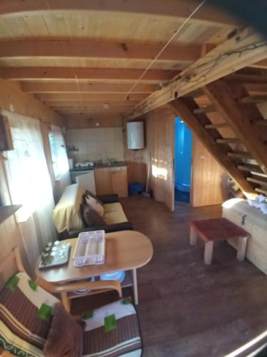 a tiny house with a table and a couch at Domki nad Sanem in Lesko