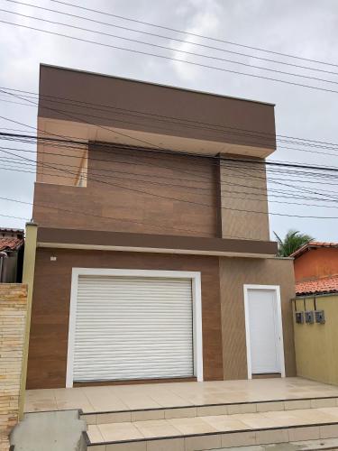 a house with two garage doors in front of it at Bella Spiaggia Suítes in Flecheiras