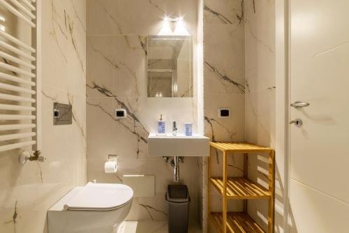 een badkamer met een toilet, een wastafel en een spiegel bij Sallustiano Apartments in Rome