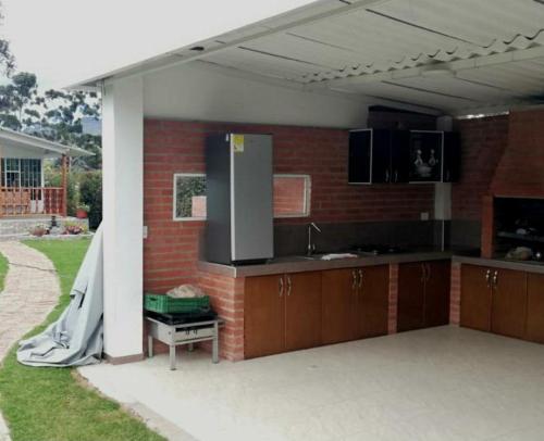 een keuken met een koelkast en een bakstenen muur bij Estadia independiente en el campo Boyacense in Duitama