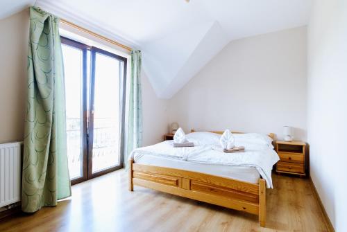 a bedroom with a bed and a large window at Penzión Vendelín in Veľké Zálužie