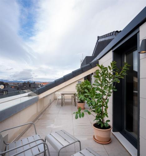 a balcony with chairs and a table on a building at Apartahotel Líbere Vitoria in Vitoria-Gasteiz