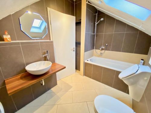 La salle de bains est pourvue d'un lavabo, de toilettes et d'une baignoire. dans l'établissement Wohnen über den Dächern von Ravensburg, stadtnah, Kamin, Klima, à Ravensbourg