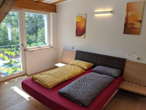 Bett in einem Zimmer mit einem großen Fenster in der Unterkunft Vidora Apartments in Oberbozen