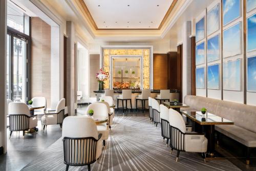 a restaurant with white chairs and tables and windows at Four Seasons Hotel One Dalton Street, Boston in Boston