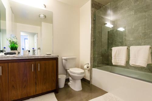 a bathroom with a tub and a toilet and a sink at Cityscape Luxury High-Rise 1-Bedroom in Los Angeles