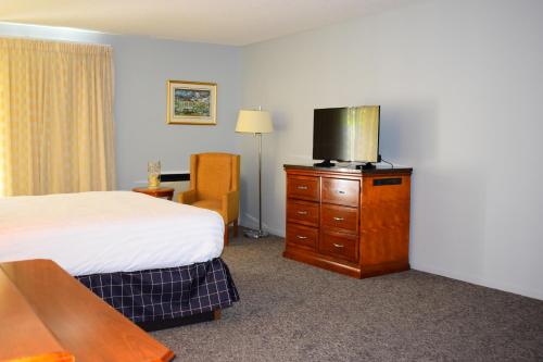 a bedroom with a bed and a television at Dundee Resort & Golf Club in West Bay