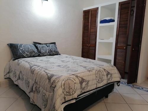 una camera da letto con un letto con un piumone e cuscini di Departamento Boulevard MZO a Manzanillo