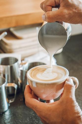 a person is holding a cup of coffee at Nomad Hotel - Xábia Port in Jávea