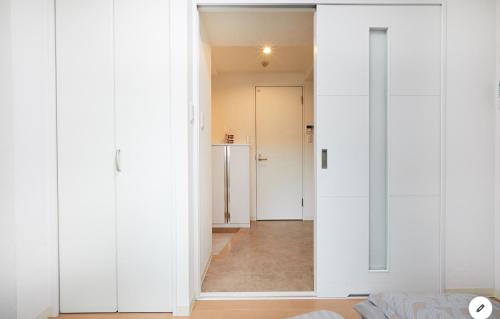 Cette chambre dispose de murs blancs et d'un couloir. dans l'établissement Marvelous Kinshicho - Vacation STAY 12904v, à Tokyo