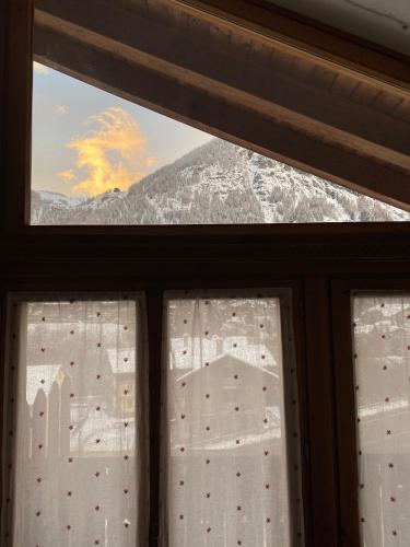 a view of a snowy mountain from a window at Hotel Walser Courmayeur in Courmayeur