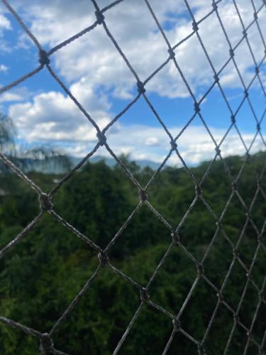 a wire fence with a view of a forest at Apartamento Alto Padrão - Home Resort Laguna in Riviera de São Lourenço