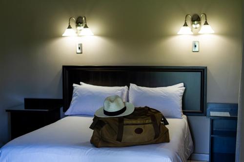 a hat and a backpack sitting on a bed at Machauka Lodge in Lephalale