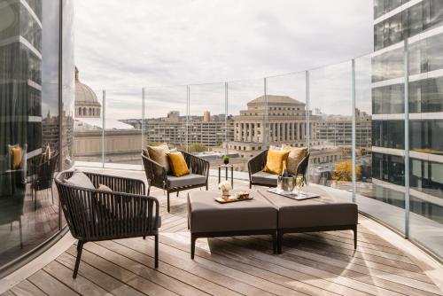 a balcony with chairs and a table on a building at Four Seasons Hotel One Dalton Street, Boston in Boston