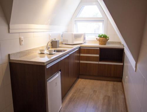 a small kitchen with a sink and a window at Hotel Fioreze Centro in Gramado