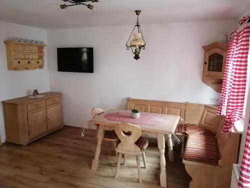 ein Esszimmer mit einem Tisch und Stühlen sowie einem TV in der Unterkunft S´ Kellerstoeckl in Fehring